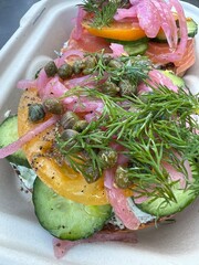 Fancy fresh bagel with salmon, capers, chives, cucumber and cream cheese toppings - 762509105