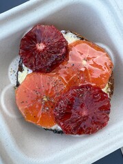 Bagel topped with cream cheese and fruit slices - 762509111