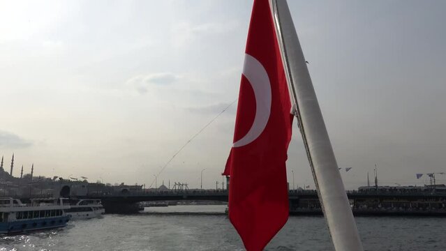 Istanbul, Turkey A Turkish flag blows off the stern of a passenger ferry under the Galata Bridge.  