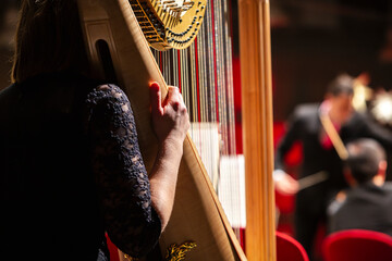 Hand einer Musikerin an einer Harfe