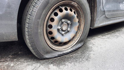 Selective focus flat tire of old car park on the street waiting for repair