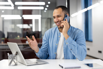Smiling businessman talking on phone in office