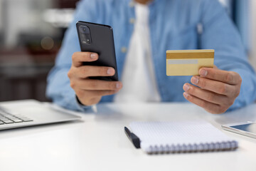 Man holding credit card and smartphone for online payment
