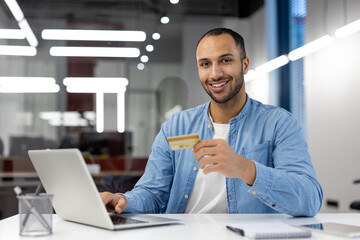Confident man shopping online with credit card