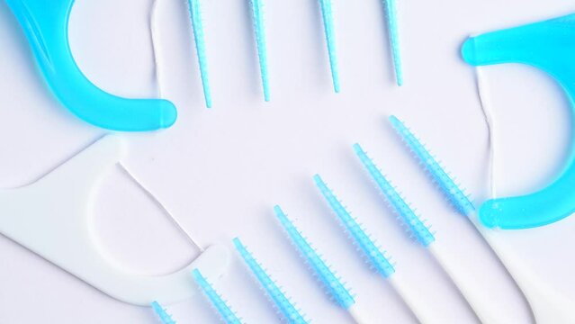 Interdental toothpick brushes and tooth floss, rotation on white background, macro shot. Dental hygiene. Oral care kit. Dentist concep