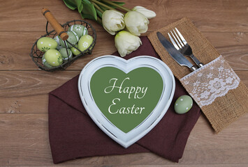 The text Happy Easter written on a heart with Easter decorations.