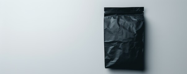 Mockup Black Pouch Standing on a Smooth White Surface in Soft Light