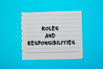 Roles and responsibilities words written on torn paper piece with blue background. Conceptual symbol. Copy space.