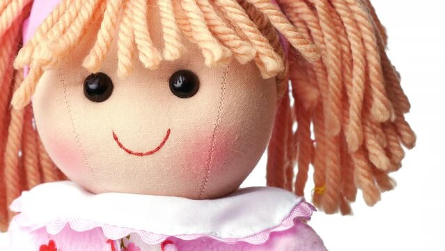 Closeup face rag doll smiling on a white background