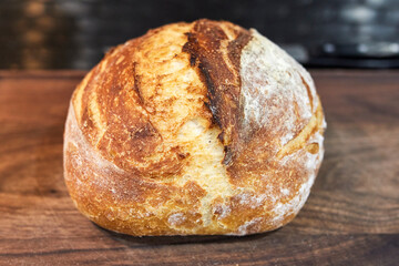home made loaf of white bread resting on the countertop in the kitchen 