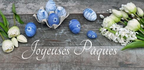 Carte de voeux Joyeuses Pâques. Décoration avec des fleurs, des œufs de Pâques et l'inscription...