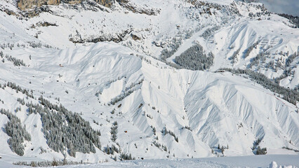 Heavy snow covered mountains and ski resort from above on a sunny day. Dolomites mountains, Italy, South Tyrol. Beautiful bird view from Dolomiti Superski area.