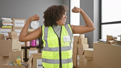 African american woman volunteer celebrating success in warehouse - Powered by Adobe