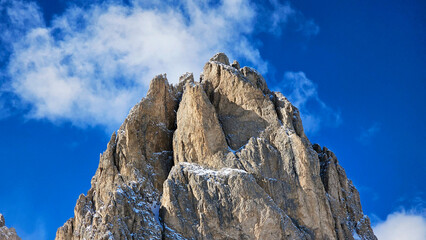 Mountain silhouette and close up structure of Dolomites rocks after heavy snowfall with blue sky. 