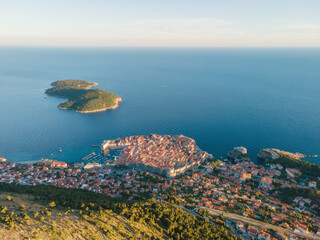 Aerial establishing shot of old town of Dubrovnik with island on Adriatic sea, Dalmatia, Croatia. Medieval city fortress with harbor and yachts. Drone view. Travel destination - 762562748