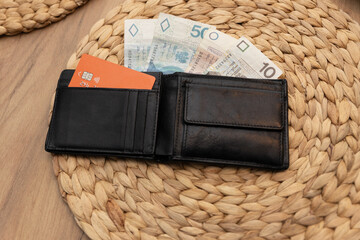 
Portfel z kartą kredytową w kolorze pomarańczowym, obok banknotu o nominale złotowym, reprezentuje koncepcję płacenia rachunków wyłącznie kartą lub korzystania z gotówki fizycznej, w kontekście wydat - obrazy, fototapety, plakaty