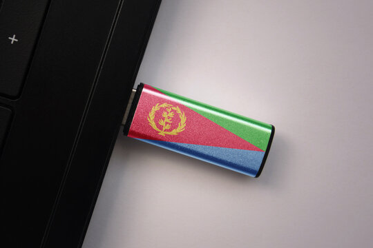 usb flash drive in notebook computer with the national flag of eritrea on gray background. - Powered by Adobe