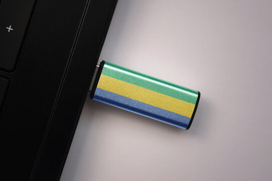 usb flash drive in notebook computer with the national flag of gabon on gray background. - Powered by Adobe