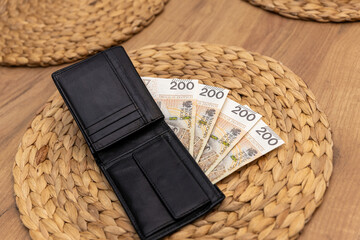 800 złotych rozłożonych na portfelu, obok smoczka, reprezentuje koncepcję pomocy państwa w...