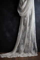 Exquisite white lace fabric elegantly draped over a dark slate background