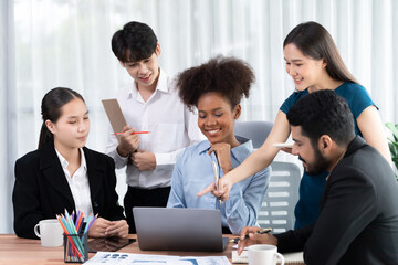 Happy diverse business people work together, discussing in corporate office. Professional and diversity teamwork discuss business plan on desk with laptop. Modern multicultural office worker. Concord