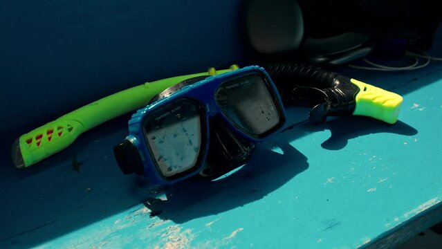 A blue snorkelling mask lies in the boat on the seat.
