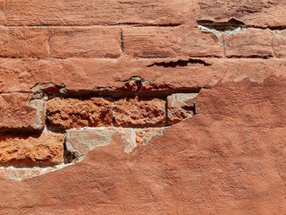 Red brick wall of an old building with crumbling plaster. Copy space. Selective focus.