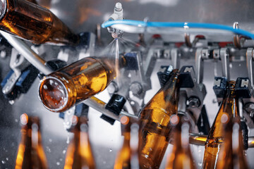Process pasteurization Brown plastic bottles with beer, moving on conveyor. Concept production line...
