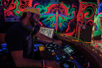 DJ specializing in Bollywood music playing music in a nightclub set in India