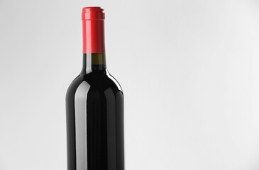 Bottle of expensive red wine on light background. Space for text