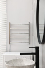 Fototapeta na wymiar Modern heated towel rail on wall in bathroom