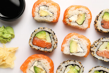 Delicious sushi rolls on white background, flat lay