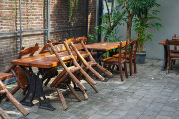 Fototapeta na wymiar simple minimalist wooden tables and chairs for sitting and drinking coffee in a coffee shop with a natural atmosphere