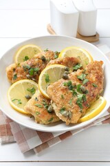 Delicious chicken piccata on white table, closeup