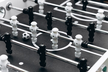 table football, board game for children and adults, entertainment events for celebrating weekends and holidays, black and white figurines and soccer ball - obrazy, fototapety, plakaty