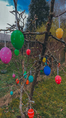 Fototapeta na wymiar Easter joy blossoms around a tree adorned with vibrant Easter eggs, radiating the spirit of celebration and renewal