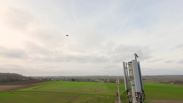 Inspection par drone d'une antenne-relais de t&eacute;l&eacute;communications, en fin de journ&eacute;e.