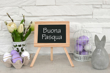 Biglietto d'auguri Buona Pasqua. Buona Pasqua su tavola di ardesia con fiori e uova di Pasqua.