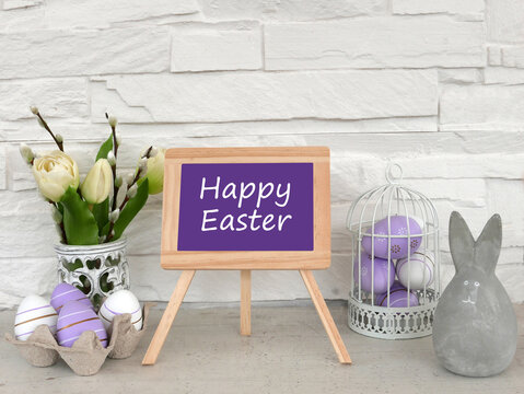 Greeting card Happy Easter. Happy Easter on slate board with flowers and Easter eggs.
