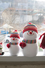 christmas snowman doll on a window frame.