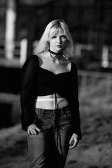 Portrait of a young beautiful blonde girl in a black coat. Black and white photo.