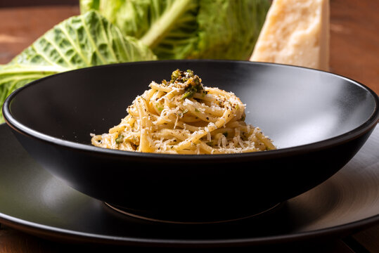 Piatto di deliziosi spaghetti conditi con cavolo verza e pecorino, pasta italiana 
