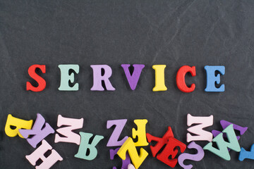 SERVICE word on black board background composed from colorful abc alphabet block wooden letters,...