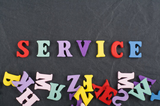 SERVICE word on black board background composed from colorful abc alphabet block wooden letters, copy space for ad text. Learning english concept.