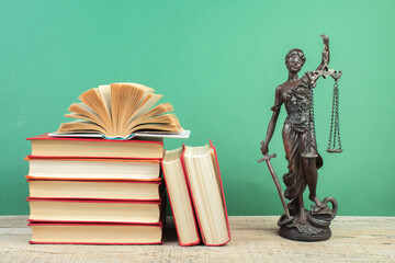 Law concept - Open law book scales, Themis statue on table in a courtroom or law enforcement office.