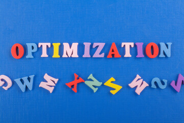 OPTIMIZATION word on blue background composed from colorful abc alphabet block wooden letters, copy...