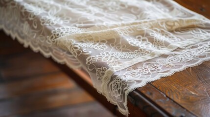 A delicate lace table runner, its intricate patterns cascading gracefully over a polished wooden surface, evoking the elegance of a formal dinner.