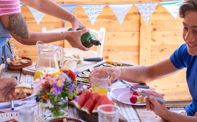Inviting colorful table in outdoors with drinks and vegetarian food, family people sharing brunch