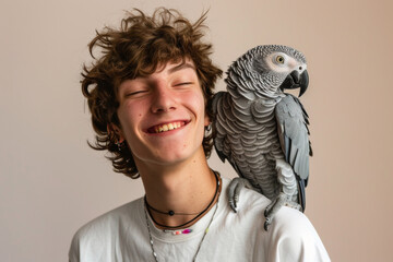 grey jaco pet parrot sitting on a man’s shoulder, portrait of male with domestic african parakeet on plain background