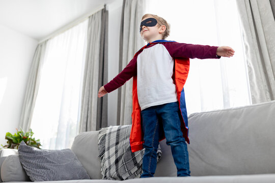 Child in Superhero Costume Playing at Home